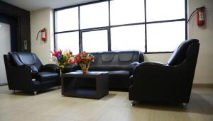 a waiting room with black leather furniture and flowers on a table at Hotel Green Park Elite in Kākināda