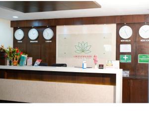 a reception desk with clocks on the wall at Hotel Green Park Elite in Kākināda