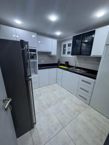 a kitchen with white cabinets and a black refrigerator at The Royal Sea View Suite in Port Said +17 photos