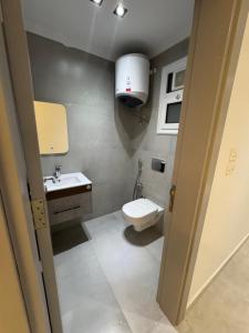 a small bathroom with a toilet and a sink at The Royal Sea View Suite in Port Said