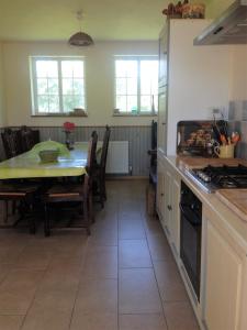 a kitchen with a table and a dining room at Holiday home La Ransonniere de Bas in Romagny