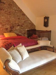 a bedroom with two beds and a couch with a clock at Holiday home La Ransonniere de Bas in Romagny