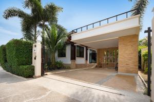 ein Haus mit einem Tor und Palmen in der Unterkunft Orchid Villa - 3 Bedrooms Pool Villa - Rawai beach in Rawai Beach