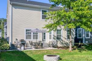 a house with a patio with a table and an umbrella at Spacious Dog-Friendly Getaway with Year-Round Pool & Hot Tub in South Haven