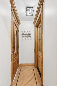 a hallway with a wooden door and white walls at Charming Garden Lvl Brownstone in Brooklyn