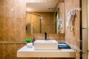 広州市にある广州维福顿白宫酒店の洗面台と鏡のあるバスルーム