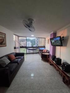 a living room with a couch and a flat screen tv at Apto Buritaca Piso 8 in Rodadero