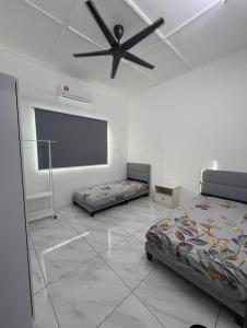 a bedroom with two beds and a ceiling fan at Intan Pearl in Teluk Intan