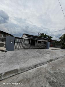 a house with a fence in front of it at Intan Pearl in Teluk Intan