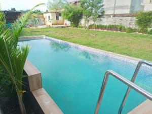a large swimming pool with blue water in a yard at Sukoon The Bliss!! in Udaipur