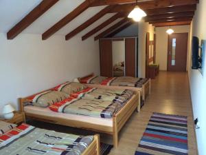 1 dormitorio con 3 camas en una habitación con pasillo en Ubytovanie U Emila, en Veľká Franková