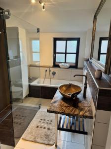 a bathroom with a sink and a bath tub at Deluxe Maisonette Ferienwohnung in Köditz