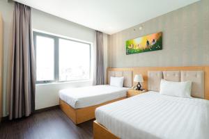 a hotel room with two beds and a window at Terra boutique hotel in Da Nang