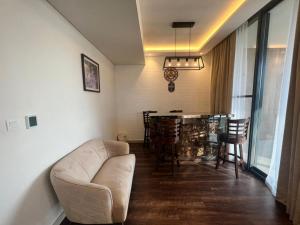 迪拜Room for rent in a luxury villa的客厅里有一张沙发、一张桌子和几把椅子 更多6张照片
