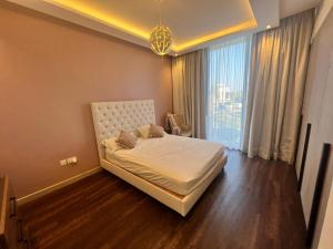 迪拜Room for rent in a luxury villa的一间卧室，里面有一张床和一扇大窗户。