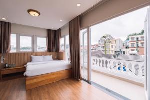 a bedroom with a bed and a large window at Ánh Phương Hotel Đà Lạt in Da Lat
