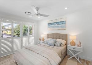 a white bedroom with a bed and a window at Riverview Apartment 2.4 in Iluka