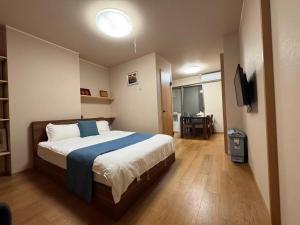 a bedroom with a bed and a television in it at Cozy House Namba in Osaka