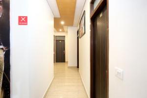 un pasillo con paredes blancas y suelo de madera y un pasillo con puerta en Collection O Gold Star, en Mohali