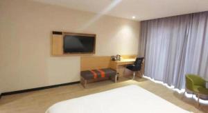 une chambre d'hôtel avec un lit, un bureau et une télévision dans l'établissement 7 Days Premium Zhengzhou Shangjie District Government, à Beixiawo 252 autres photos