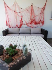 un soggiorno con divano e alcuni cactus di Villa Perla di Mare a Savelletri