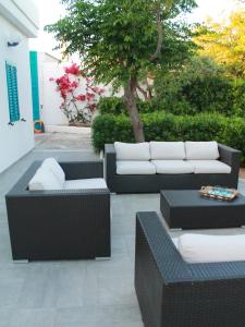 un patio con divani, tavoli e un albero di Villa Perla di Mare a Savelletri
