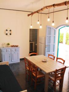 Una cocina y un comedor con mesa y sillas de madera. en Villa Perla di Mare, en Savelletri di Fasano