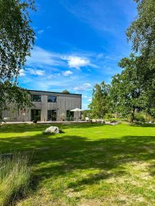 a building with a green field in front of it at Architect-Designed House With Meadow Views in Vårgårda