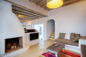 a living room with a fireplace and a couch at Mykonos Dunes Villas in Mikonos