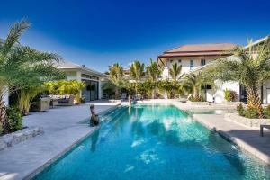 a swimming pool in front of a house with palm trees at Palm Villa - Spacious 4 Bedrooms with Private Pool in Rawai Beach