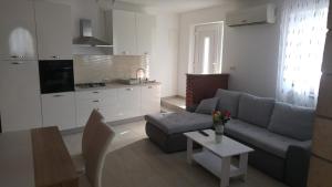 uma sala de estar com um sofá e uma mesa em Apartments and room Suza em Senj