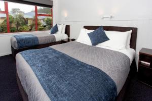 Una habitación de hotel con dos camas y una ventana. en Carters Beach Top 10 Holiday Park, en Carters Beach