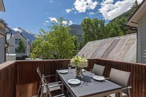 a table with a vase of flowers on a balcony at South Oak Retreat - convenient luxury by gondola! in Telluride