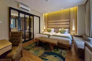 a hotel room with two beds and a couch at Wyndham Garden Yogyakarta Hotel Conference & Action Park in Sleman +60 photos