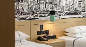 ein Hotelzimmer mit zwei Betten und einer Zeichnung an der Wand in der Unterkunft City Comfort Inn Foshan Gaoming Huaying Square in Shilong