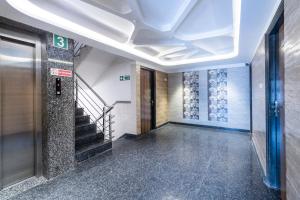 a hallway with stairs and a elevator in a building at Hotel O Platinum Inn in Bengaluru