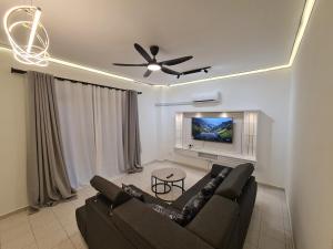 a living room with a couch and a ceiling fan at Modern Nilai Homestay at Nilai, USIM, INTI, Mila University, Aurelius Hospital, Aminah Event Hall, Sepang F1, KLIA 