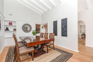 Un comedor con mesa y sillas de madera. en Cosy Home close to Sandton, en Johannesburgo