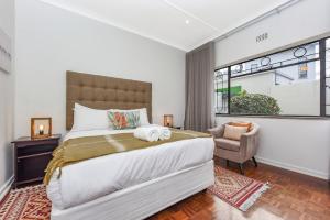 Un dormitorio con una cama grande y una silla. en Cosy Home close to Sandton, en Johannesburgo 28 fotos más