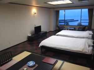 a hotel room with two beds and a balcony at Utsumionsen Ichizu in Minamichita +54 photos