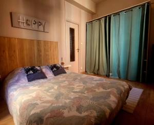 a bedroom with a bed with a floral bedspread at Escale meublée in Belfort