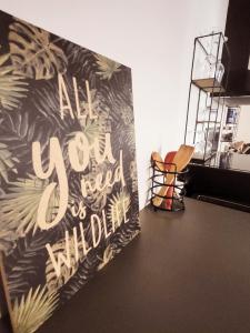 an art wall with a sign that reads all you need isillon at Escale meublée in Belfort