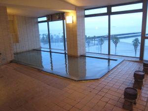 a room with a pool of water in a building at Utsumionsen Ichizu in Minamichita