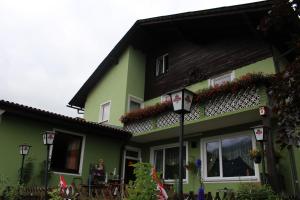 una casa verde con un tetto nero e fiori sopra di Gasthaus Zum Stadtwald a Rottenmann