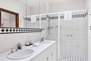a white bathroom with two sinks and a shower at Casa del Mar in Marengo +17 photos