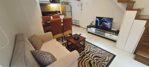 a living room with a couch and a television at 2 BR loft-type condo Fort Victoria in Manila