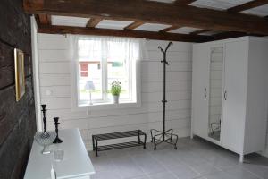 ein weißes Zimmer mit einer Bank und einem Fenster in der Unterkunft Uddebogård 2 in Hjo