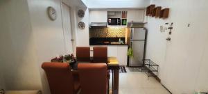 a small kitchen with a table and chairs in a room at 2 BR loft-type condo Fort Victoria in Manila