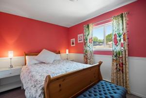 a bedroom with red walls and a bed and a window at Pet friendly Family home in Shawnigan Lake in Shawnigan Lake