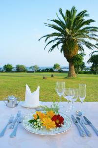 a table with a plate of flowers and wine glasses at Shirahama Ocean Resort in Minamiboso